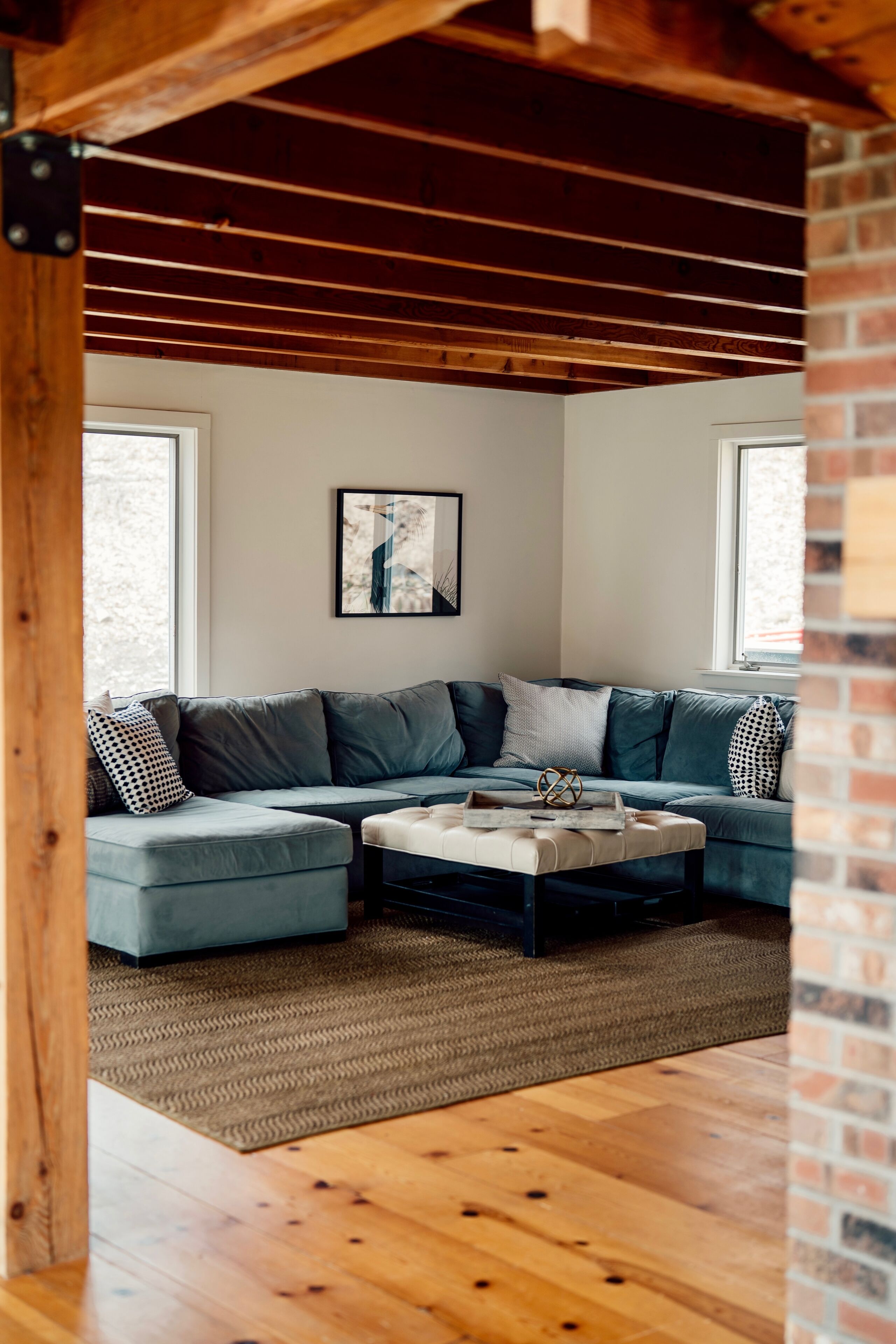 Una sala de estar moderna con un sofá modular, una mesa de centro y un amplio ventanal que proporciona luz natural.