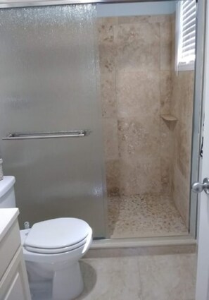 Regadera, secadora de cabello, toallas, papel de baño 