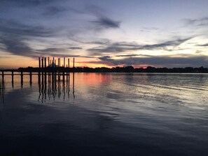 A calm body of water reflecting a sunset with a pier extending into it. - Riverfront One Bedroom Fishing Cottage w/ boat dock-Summer Specials!! (Sebastian)