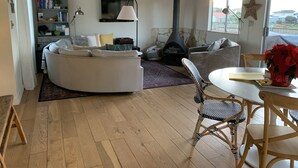 Una sala de estar acogedora con chimenea, una mesa redonda de comedor y una zona de estar cómoda.