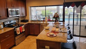 A modern kitchen with granite countertops, stainless steel appliances, and a large island.