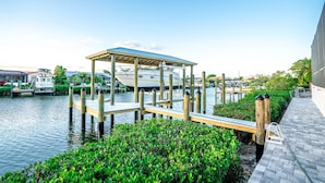 A dock with a covered pavilion, wooden walkways, and water.