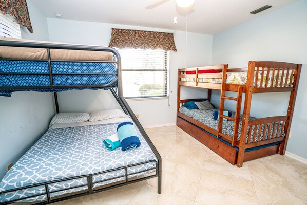 Une chambre avec deux lits superposés, l’un avec un matelas à motifs et l’autre avec un motif floral.