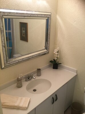 Een bad/douchecombinatie, een haardroger, handdoeken, zeep