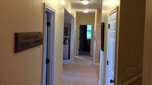 A hallway with beige walls, white doors, and a light fixture on the ceiling. - Beautiful Long Range Mountain Views, Minutes from Downtown Hendersonville, NC (Hendersonville)