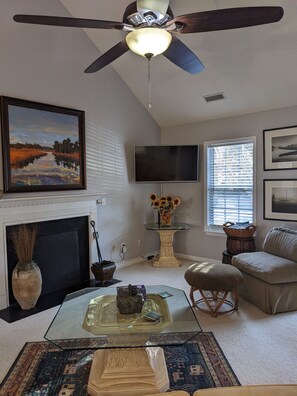 Relax in this inviting living room with a fireplace, flat-screen TV, and comfortable sofa.
