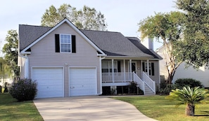Stunning two-story home with a central entrance, covered porch, and staircase leading to the upper floor.
