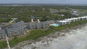 A coastal hotel with multiple buildings, a swimming pool, and a beach view. - OIBV 716 - Island Dream: Oceanfront condo in Oak Island, perfect for family getaways! (Oak Island)
