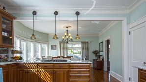 A spacious kitchen with a large island, wooden cabinets, and pendant lighting.