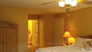 A bedroom with a bed, a nightstand, a lamp, a wardrobe, and a ceiling fan. - Beautiful Mountain views with private balcony close to Asheville, NC (Barnardsville)