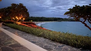 A coastal walkway with stone paving, lush greenery, and a view of the sea under a cloudy sky. - NEWLY RENOVATED Popular Mauna Kea Condo - Spectacular Panoramic Ocean Views (Waimea)