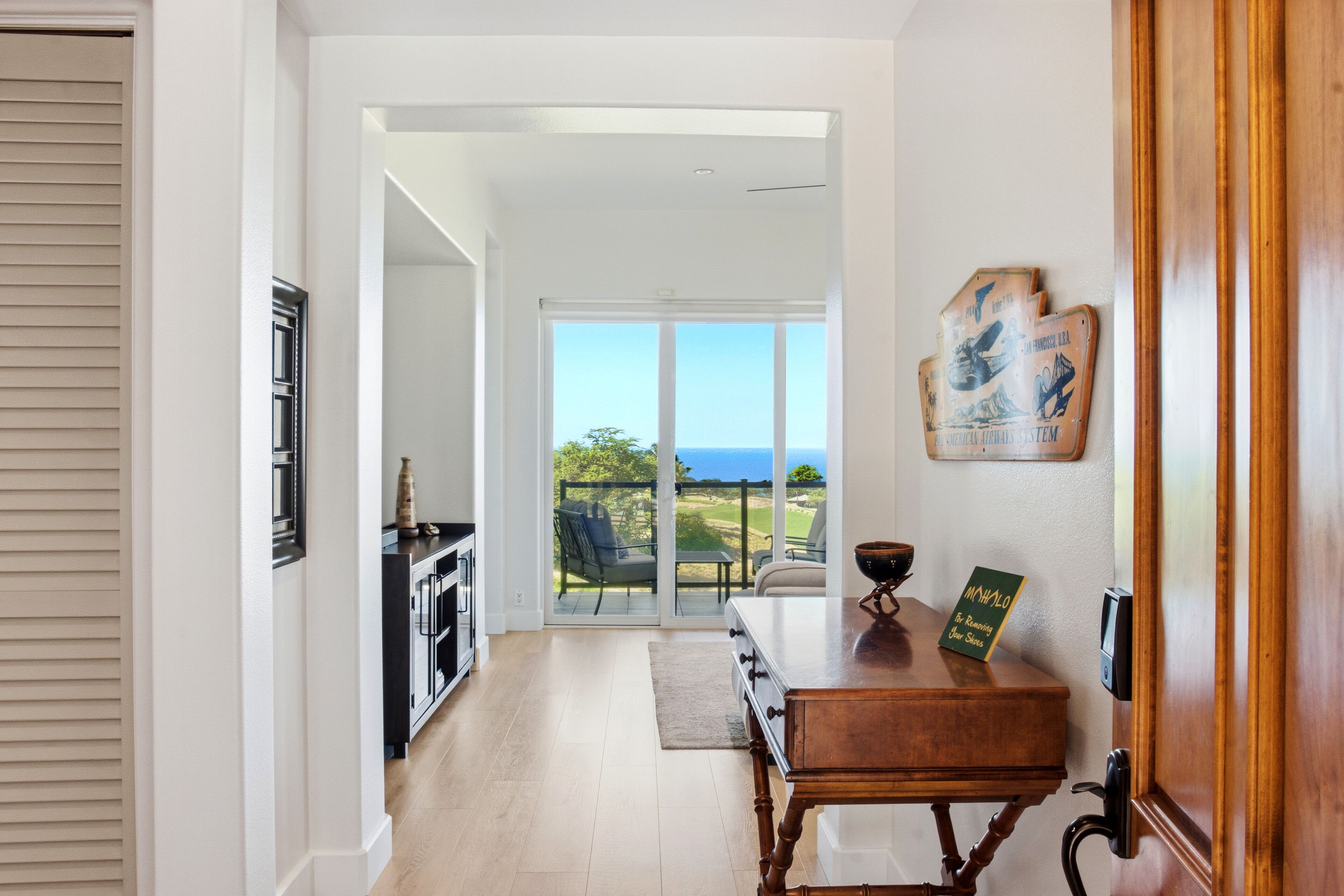 Una cocina moderna con vistas al exterior, una mesa de madera con un libro y un ventanal corredero que da a un balcón.