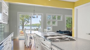 Una cocina con una isla grande, armarios blancos y vistas al exterior.