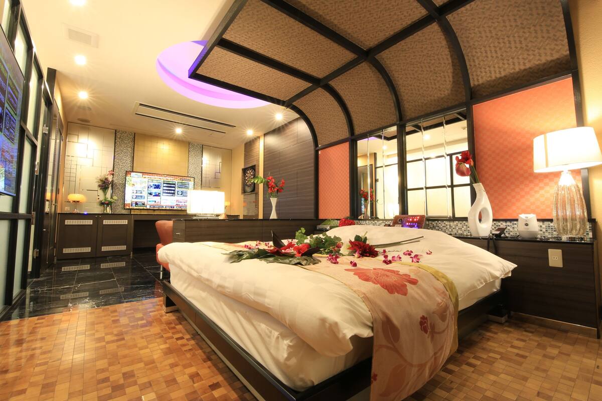 Ein Hotelzimmer mit einem großen Bett, einem Schreibtisch, einem Badezimmer und Blick auf die Stadt.