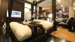 A modern hotel room with a large bed, a seating area, and a digital screen displaying information. - HOTEL GRASSINO URBAN RESORT URAWA - Adult Only (Saitama)