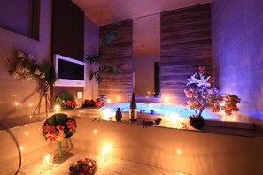 A modern spa area with a hot tub, candles, and floral arrangements. - HOTEL RIRAKU - Adult Only (Tokorozawa)