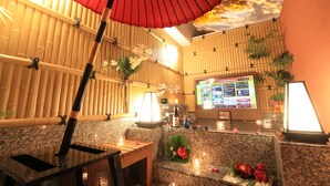 A traditional Japanese-style interior with bamboo walls, a reception desk, and a digital menu board. - HOTEL RIRAKU - Adult Only (Tokorozawa)