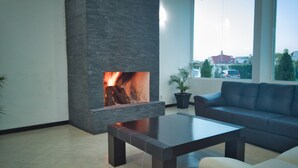 A modern living room with a stone fireplace, a sofa, and a coffee table. - Hotel Osalle Inn (Chignahuapan)