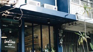 A building with a sign reading "Local Time Bangkok" and another sign indicating "rooms | cafe | lifestyle". - Local Time Bangkok - Hostel (Bangkok)