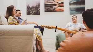 A group of people sitting on a couch in a room with three landscape paintings on the wall. - Local Time Bangkok - Hostel (Bangkok)