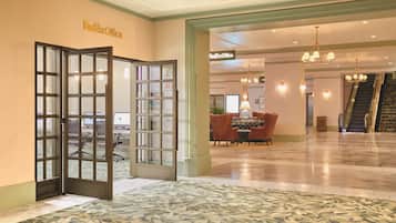 Hall di un FedEx Office con area reception, posti a sedere e un nastro trasportatore.