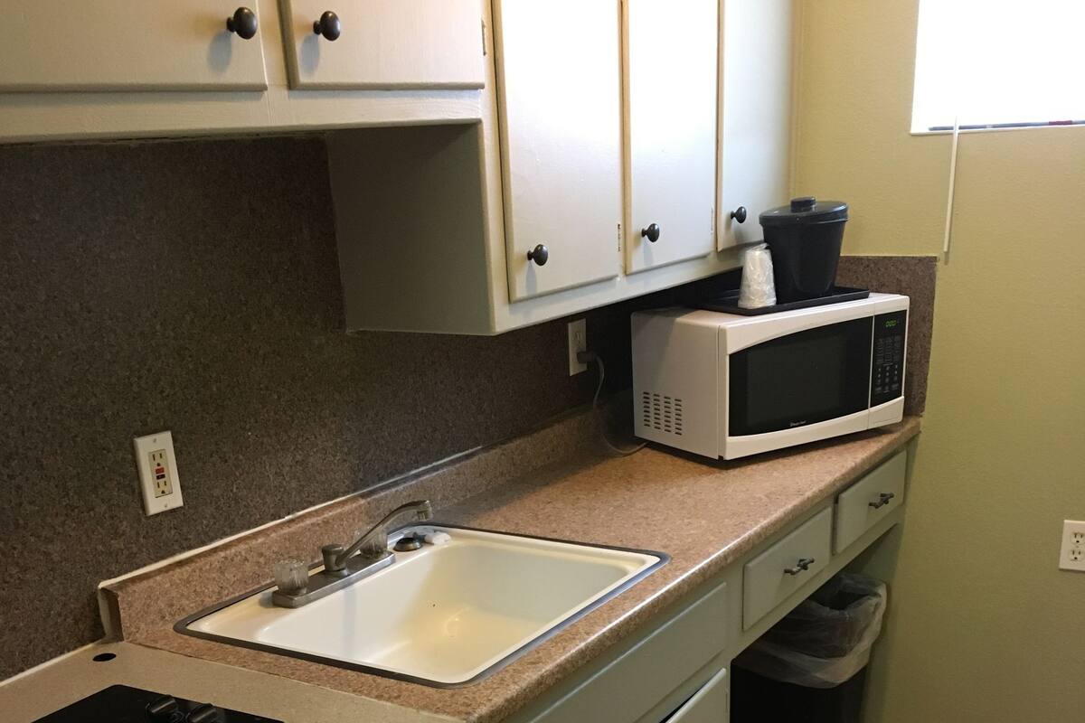 A compact kitchen with a sink, a microwave, and a dishwasher.