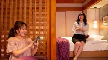 A room with a bed, a wooden partition, and a person sitting on the bed.