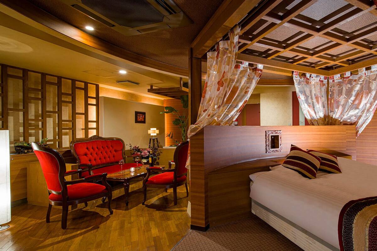 A hotel room with a bed, a desk, and two chairs.