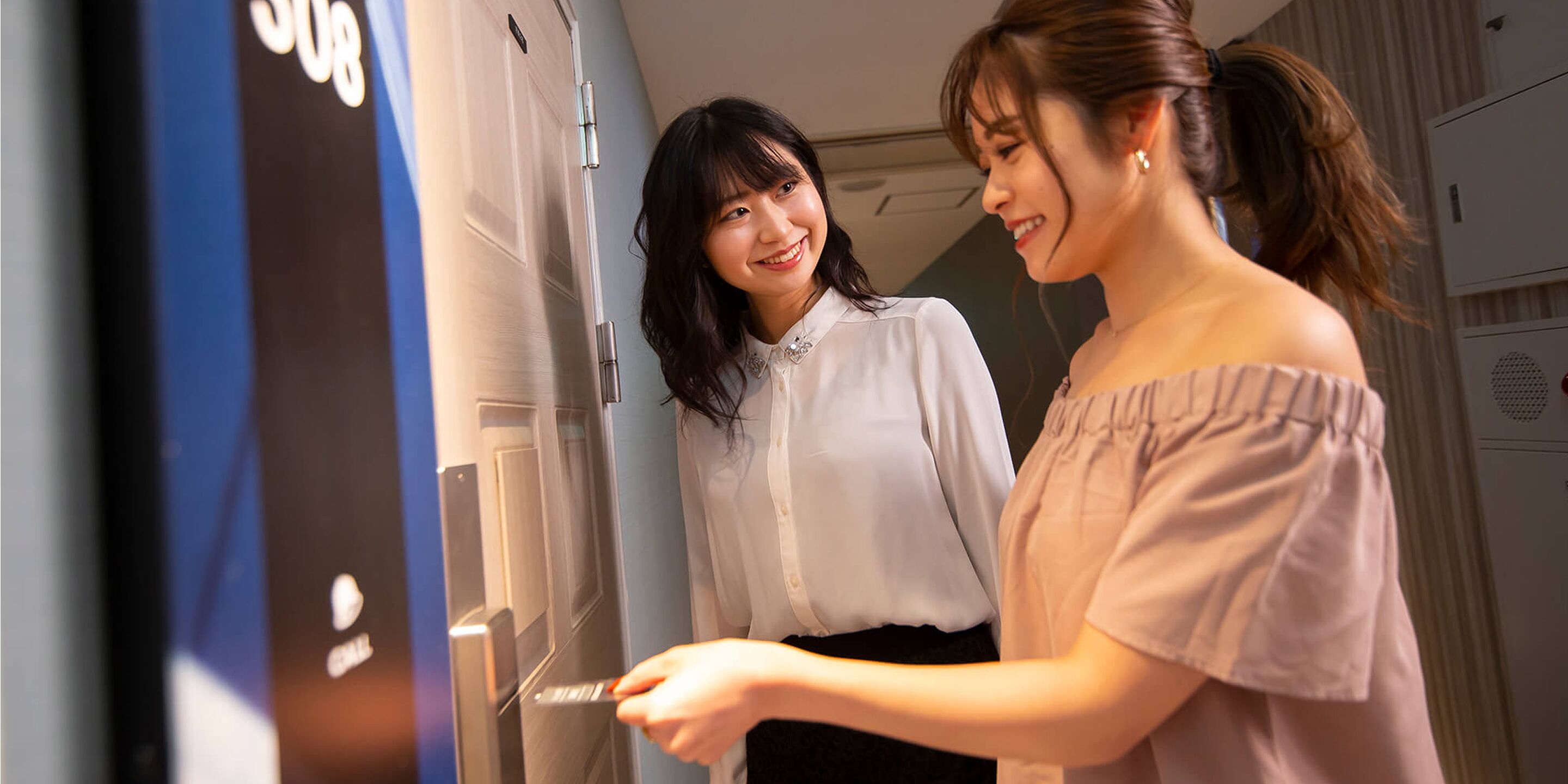 Two individuals interacting with a door, possibly in a hotel or similar accommodation.