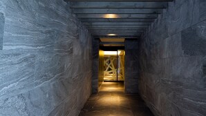 A narrow, stone-walled corridor with a wooden ceiling and a lit interior. - HOTEL U's Kouroen – Adults Only (Nishinomiya)