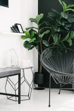 A modern room with a black wire chair, a white table, and a large green plant. - Blu Monkey Phi Phi Island (Ko Phi Phi)