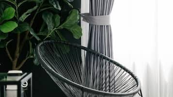 A modern chair with a metal frame and a plant beside it.