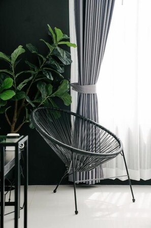 A modern chair with a metal frame and a plant beside it.