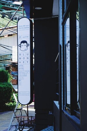 Blu Monkey Key Boutique Hotel features a distinctive sign with a stylized monkey logo, prominently displayed in front of the building.
