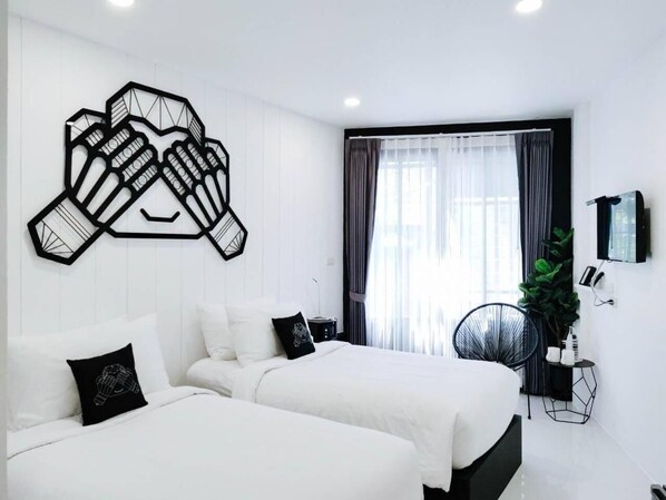 A modern hotel room with two beds, a large abstract wall art piece, a TV, and a large window with curtains.