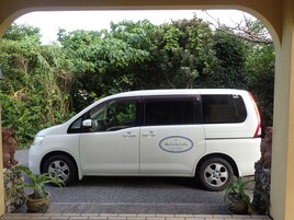 A white van parked in a driveway with a logo on the side.