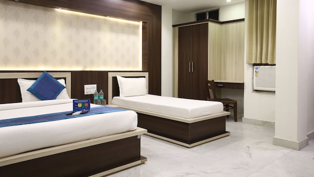 A hotel room with two beds, a desk, and a wardrobe. - Hotel Sagun (Jaipur)
