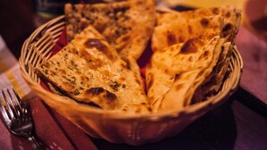 Un cistell de pa naan sobre una taula.