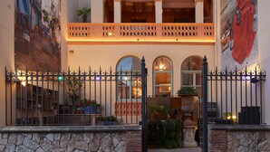 A building with a stone facade, arched windows, and a balcony with decorative railings. - Hotel Boutique La Indiana de Begur - Adults Only (Begur)