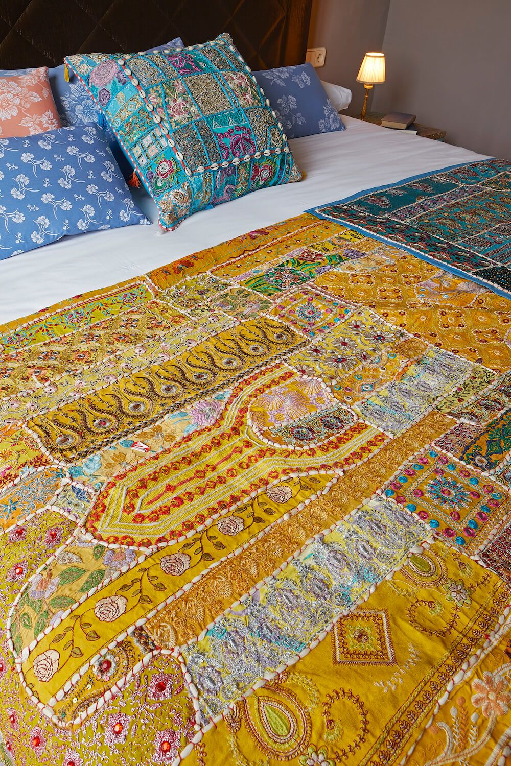 Uma cama com um edredom colorido e almofadas estampadas.