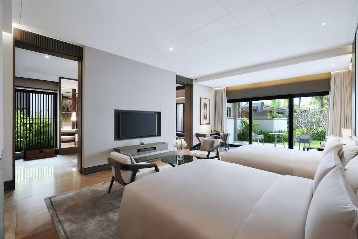 Une chambre d’hôtel moderne dotée d’un grand lit, d’un bureau, d’une télévision et offrant une vue sur l’extérieur.