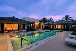 A modern resort with a swimming pool, outdoor seating, and palm trees. - Capella Tufu Bay, Hainan (Lingshui)