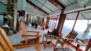 Una habitación amplia con muebles de madera, ventanas grandes y vistas al exterior.