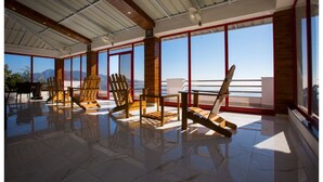Una habitación amplia con ventanas grandes, muebles de madera y un suelo reflectante.
