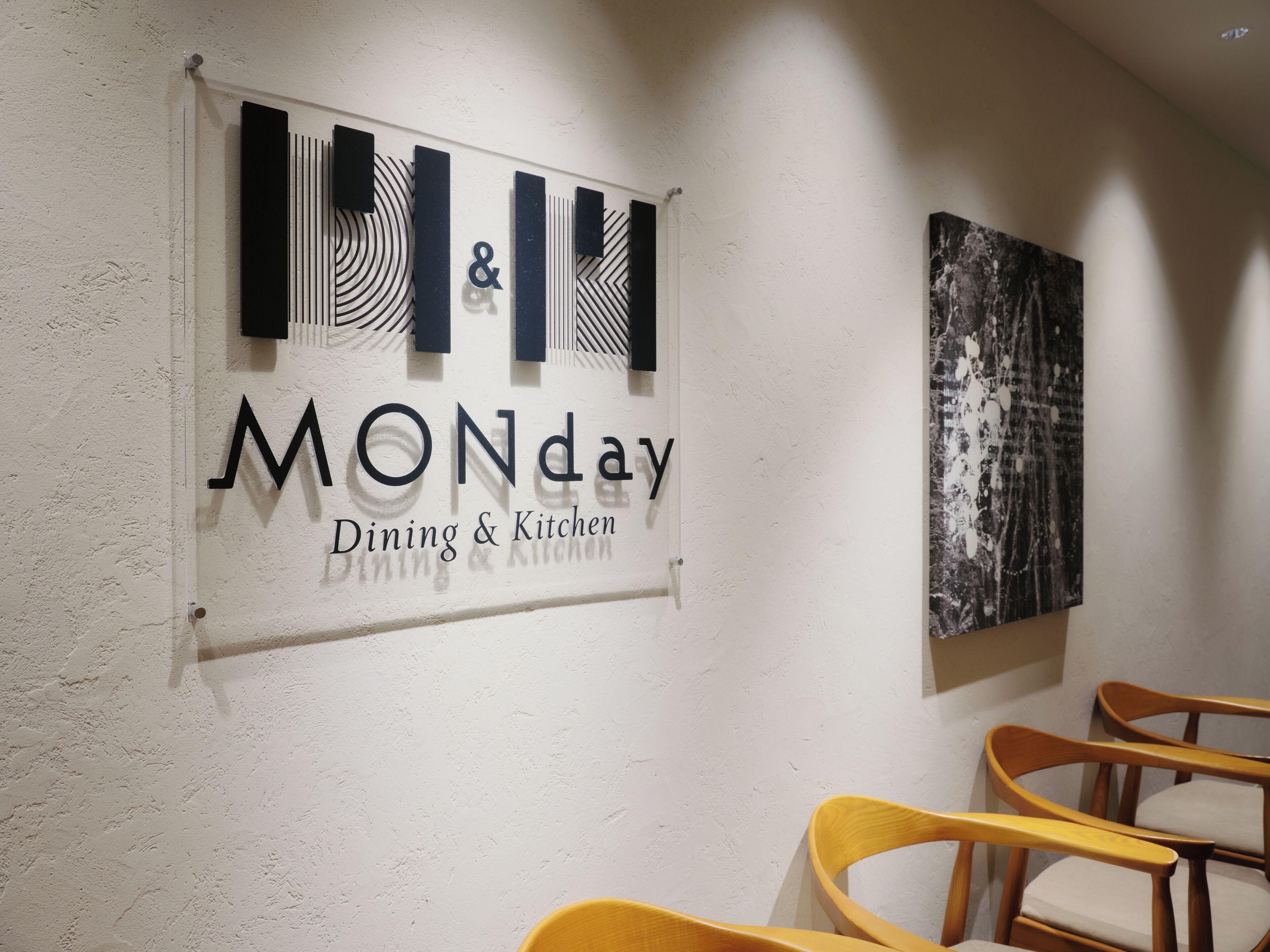A wall sign indicating 'MONday Dining & Kitchen' with a modern design and abstract art.