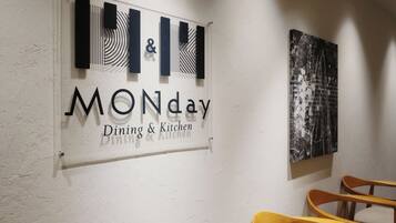 A wall sign indicating 'MONday Dining & Kitchen' with a modern design and abstract art.