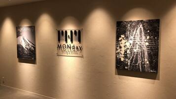 A wall with three artworks and a sign.