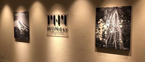 A wall with three artworks and a sign.