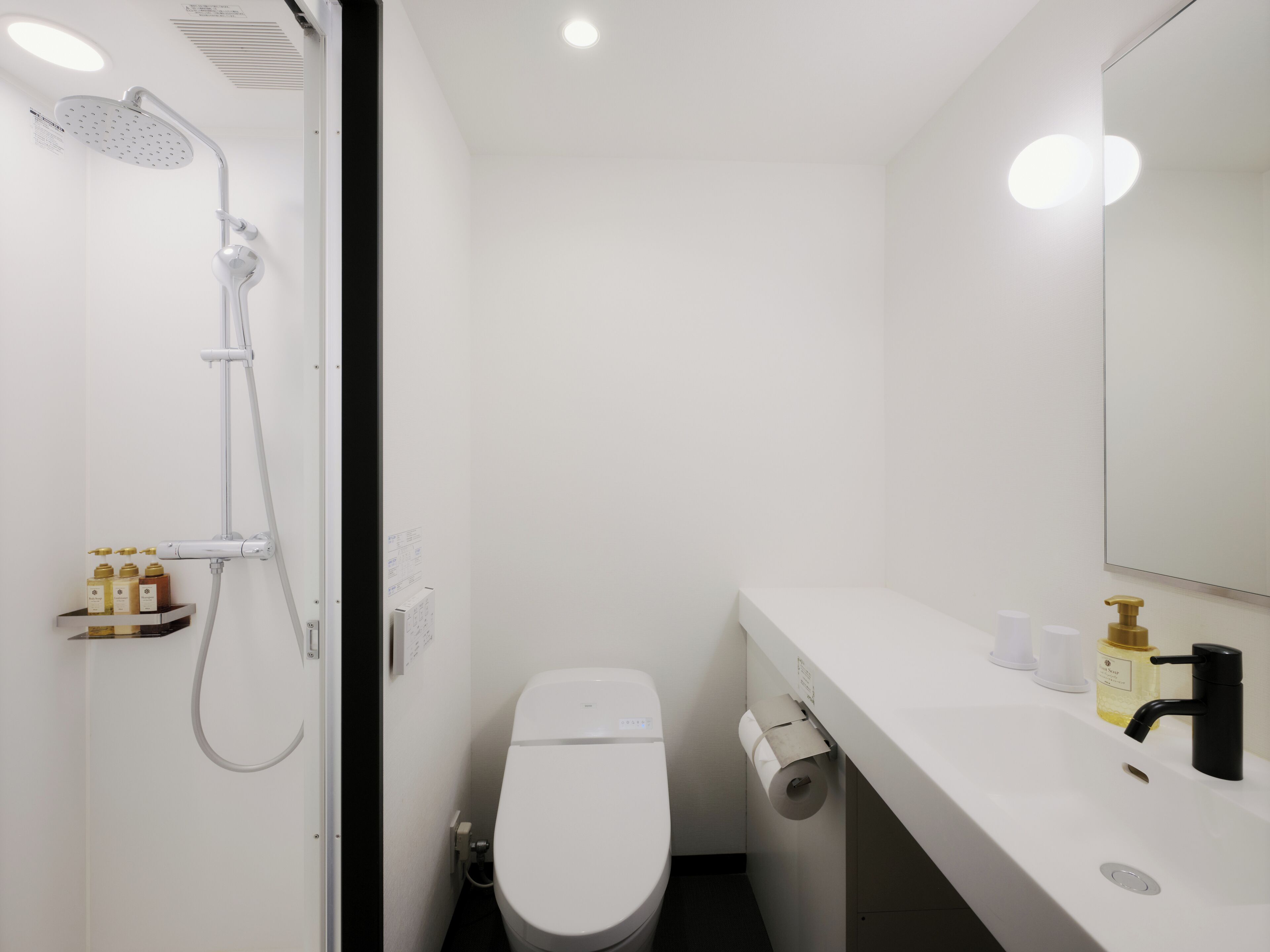 Un baño moderno con ducha, inodoro y lavamanos.