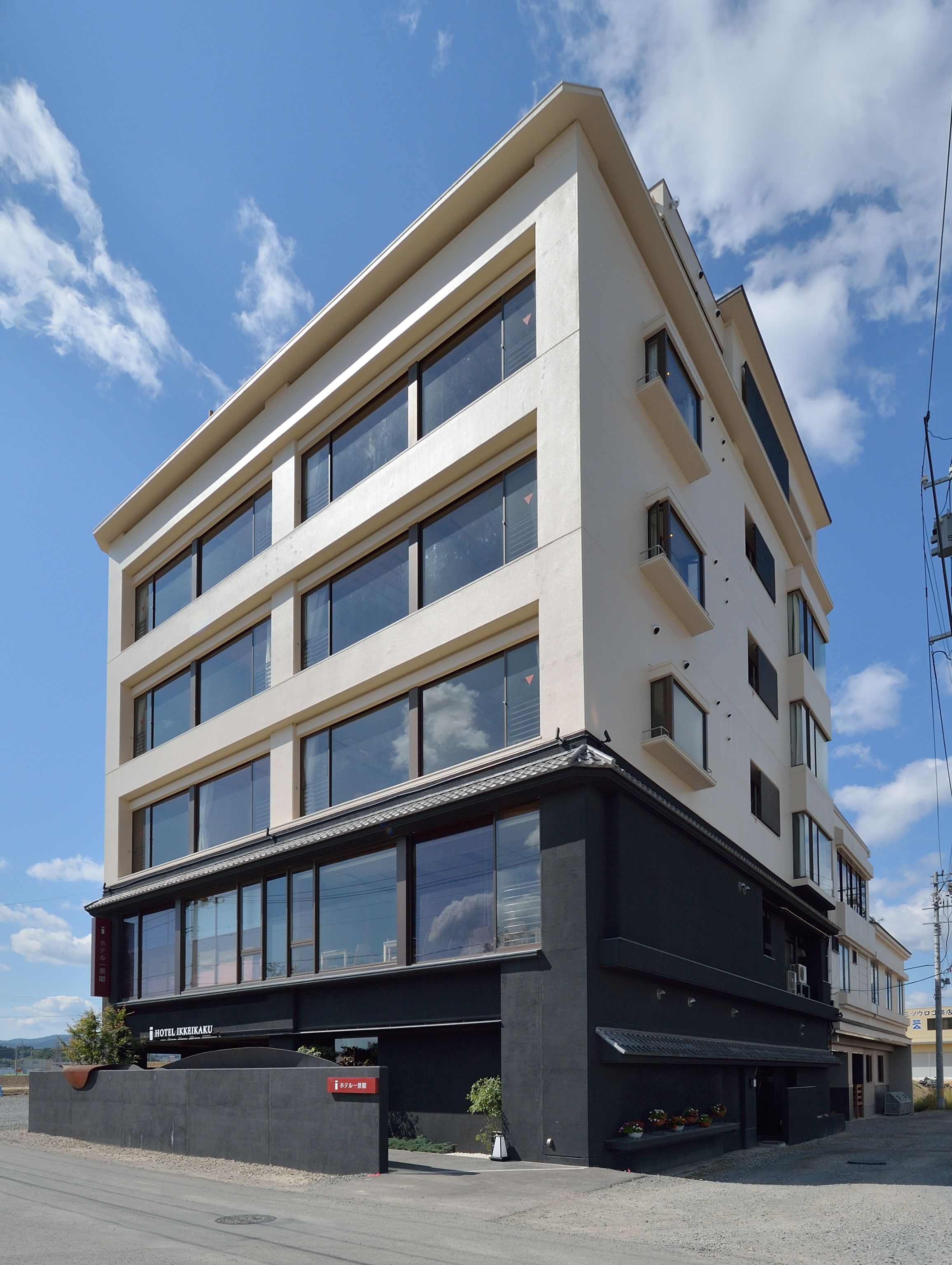 Un hôtel à plusieurs étages, doté d’une façade sobre, de grandes fenêtres et d’un hall d’entrée noir.